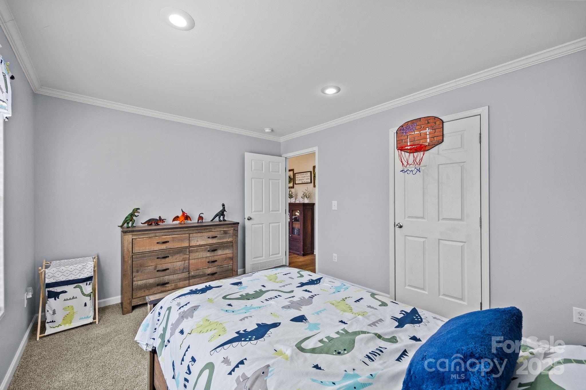 247 Aden Green Road Mill Spring, NC 28756 - Photo 29 of 48 a bedroom with a bed and a dresser in it