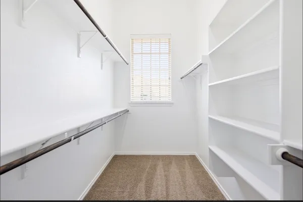 a view of an empty walk in closet with empty racks