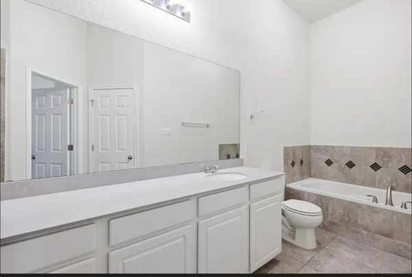 a bathroom with a granite countertop sink a toilet and a large mirror