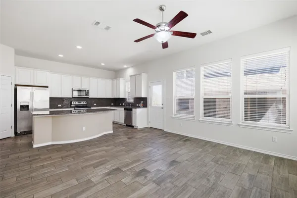 a view of kitchen with stainless steel appliances refrigerator stove microwave and cabinets
