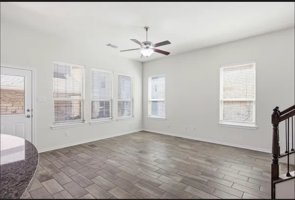 a view of an empty room with a window and a chandelier fan