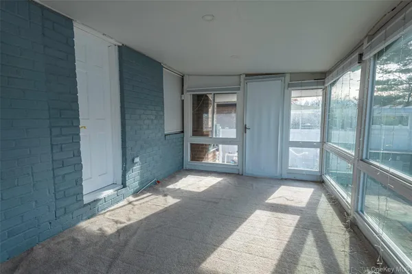 a view of empty room with wooden floor and floor to ceiling window