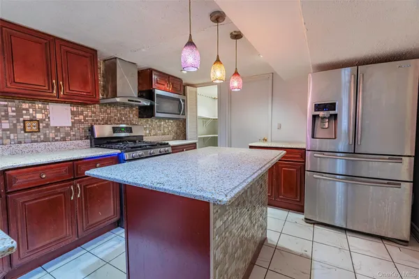 a kitchen with stainless steel appliances granite countertop a stove a sink dishwasher and a wooden cabinets