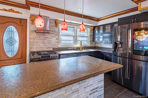 a kitchen with stainless steel appliances granite countertop a sink a stove and a wooden cabinets