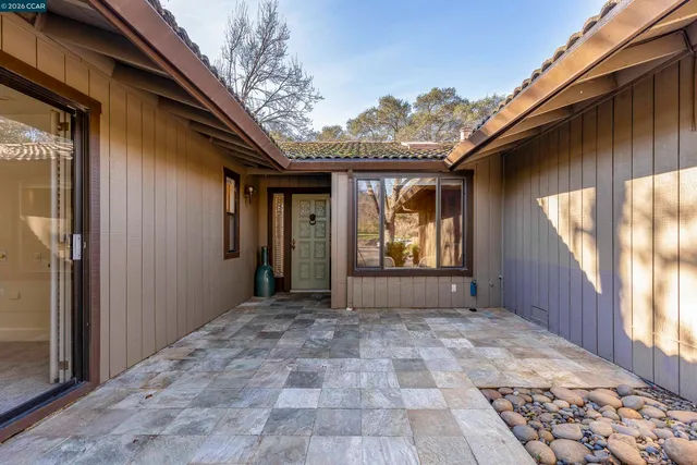 an empty room with wooden floor fireplace and windows