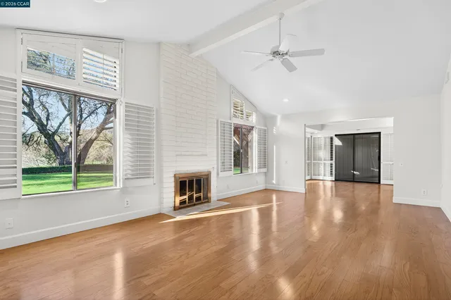 a view of a hallway with wooden floor and a cabinet