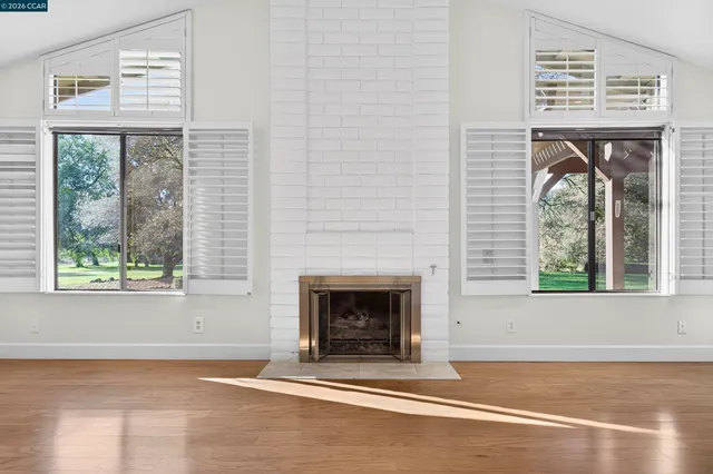 a view of a bedroom with wooden floor and a large window