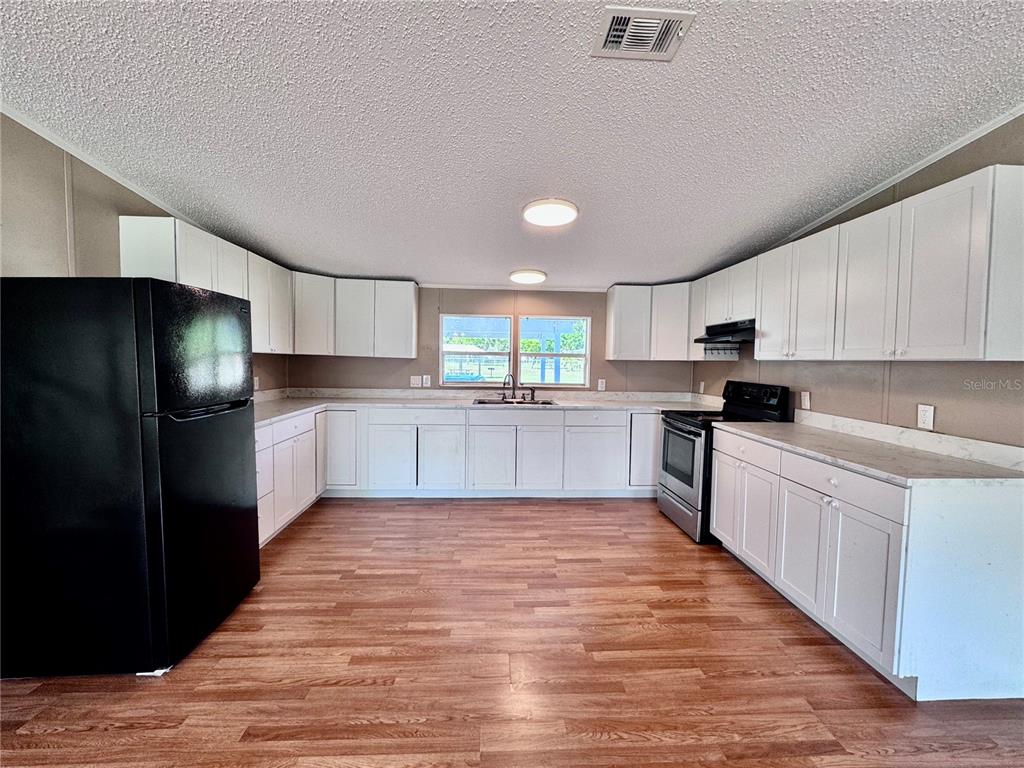 4300 Meadow Ridge Avenue Mulberry, FL 33860 - Photo 8 of 25 a large kitchen with a stove a refrigerator and a sink