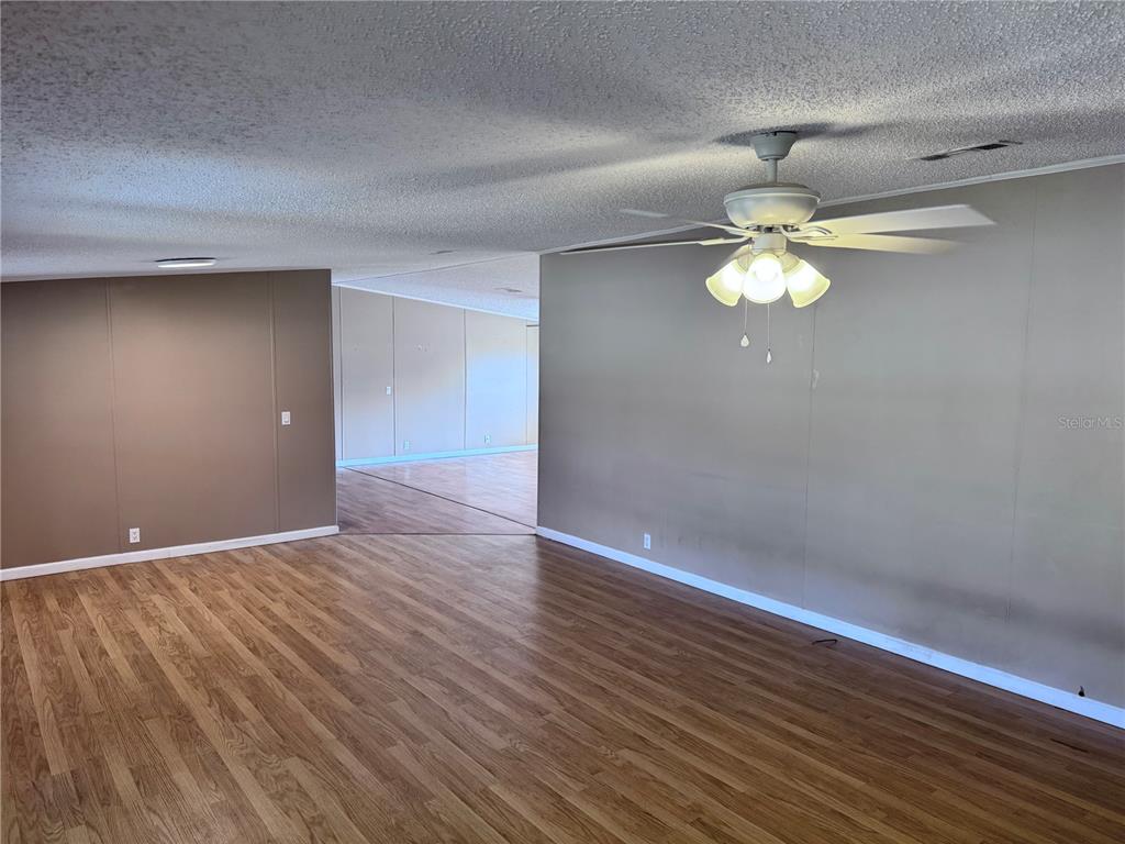 4300 Meadow Ridge Avenue Mulberry, FL 33860 - Photo 10 of 25 an empty room with wooden floor and chandelier