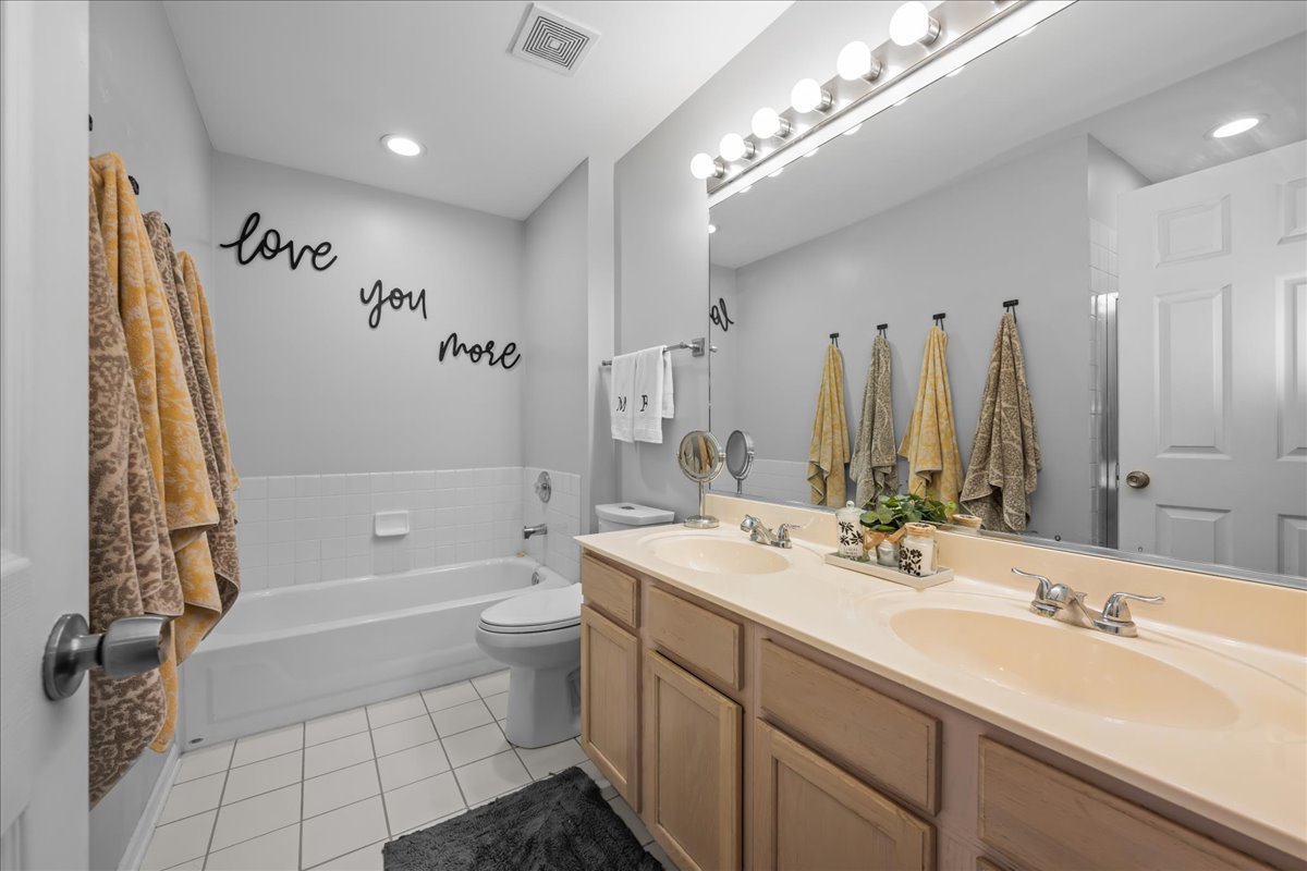 8 Ione Drive, Unit C South Elgin, IL 60177 - Photo 17 of 31 a bathroom with a double vanity sink toilet mirror and bathtub