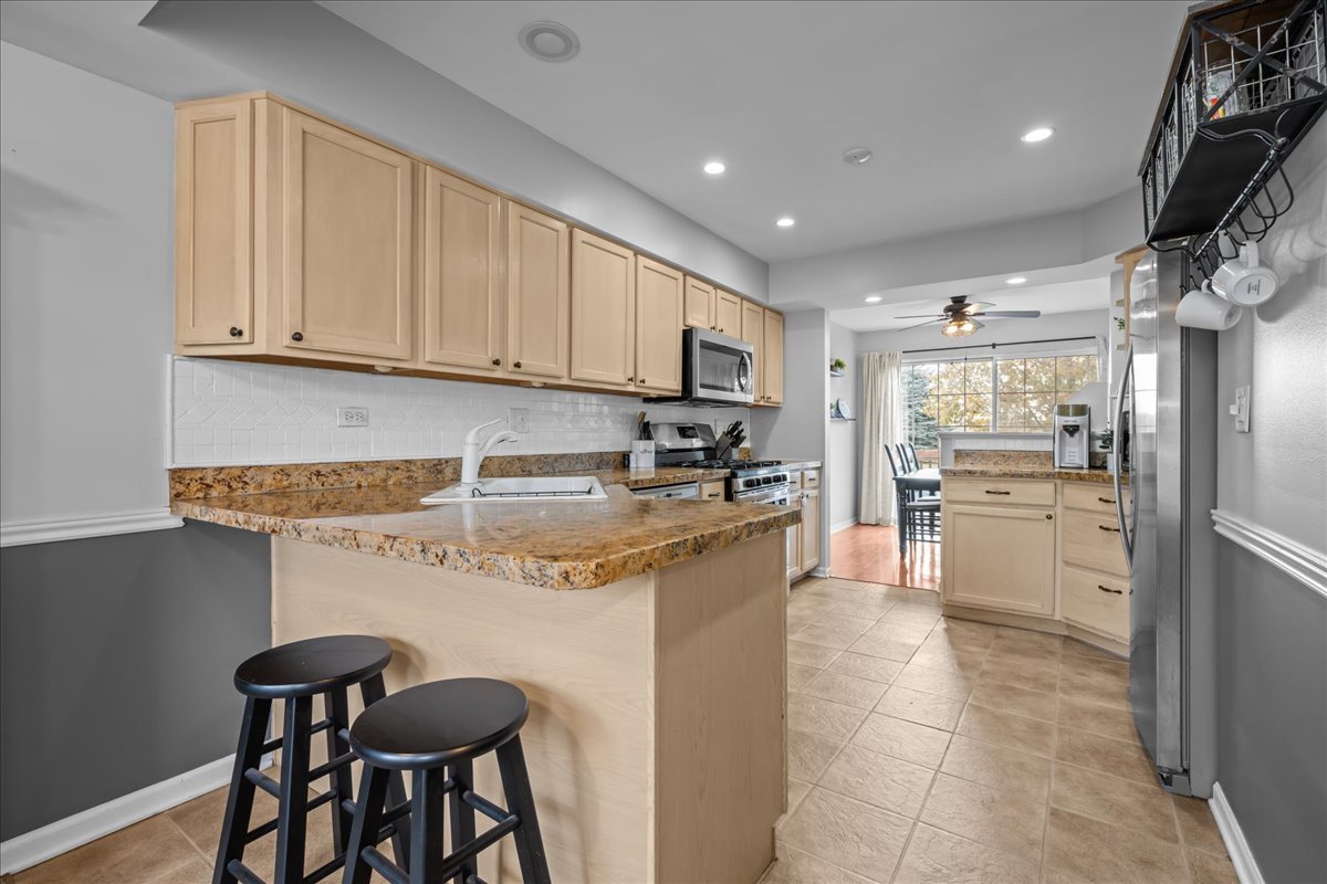8 Ione Drive, Unit C South Elgin, IL 60177 - Photo 9 of 31 a kitchen with stainless steel appliances granite countertop a stove a refrigerator and a stove top oven