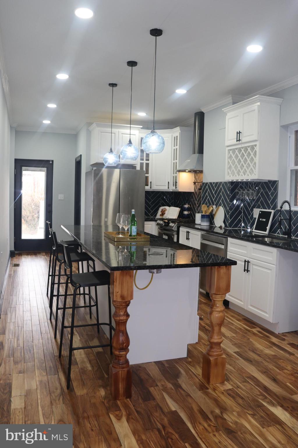 a kitchen with granite countertop a stove and white cabinets