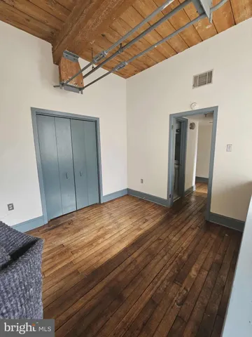 a view of empty room with wooden floor
