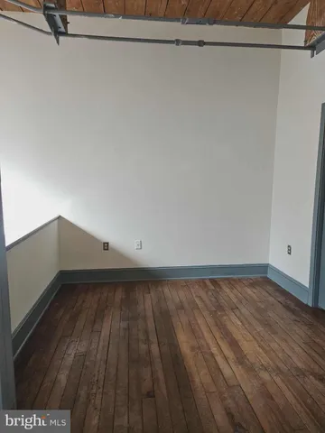 a view of a room with wooden floor and brick walls