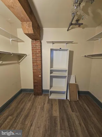 a view of walk in closet with empty racks