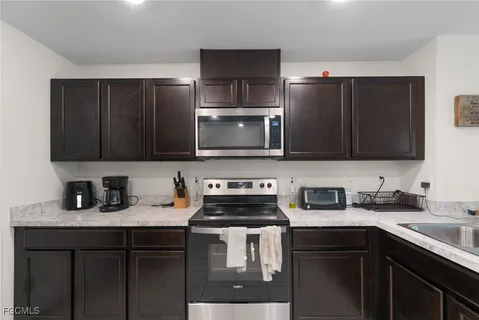 a kitchen with stainless steel appliances a stove sink microwave and cabinets