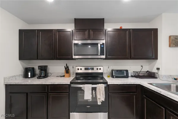 a kitchen with sink and view of living room