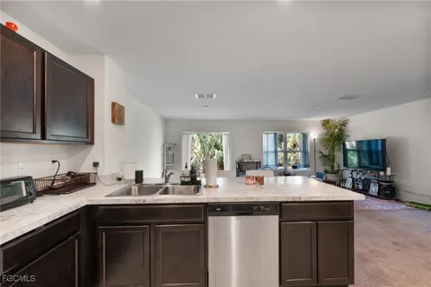 a kitchen with sink and view of living room