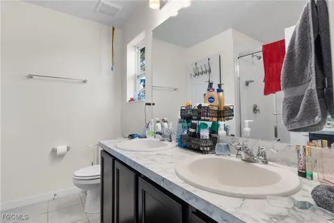 a bathroom with a granite countertop sink a toilet and a mirror