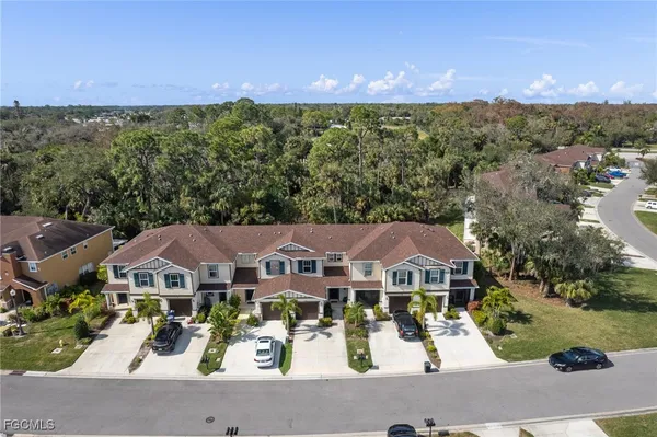 an aerial view of a city with lots of residential buildings ocean and mountain view in back