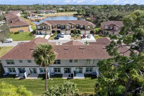 an aerial view of multiple houses with a big yard