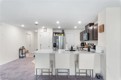 a kitchen with kitchen island granite countertop a sink and cabinets