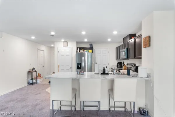 a kitchen with kitchen island granite countertop a sink and cabinets