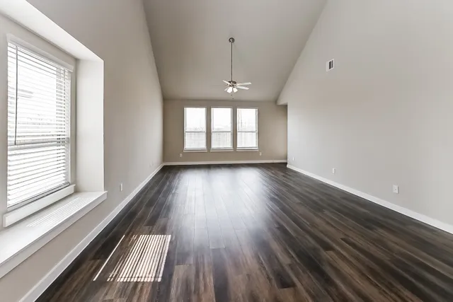 wooden floor in an empty room with a window