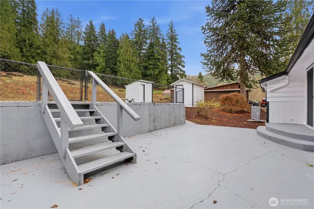 a view of a house with backyard and trees