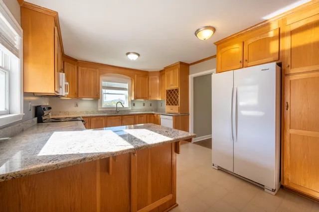 a kitchen with stainless steel appliances granite countertop a sink a stove and a microwave