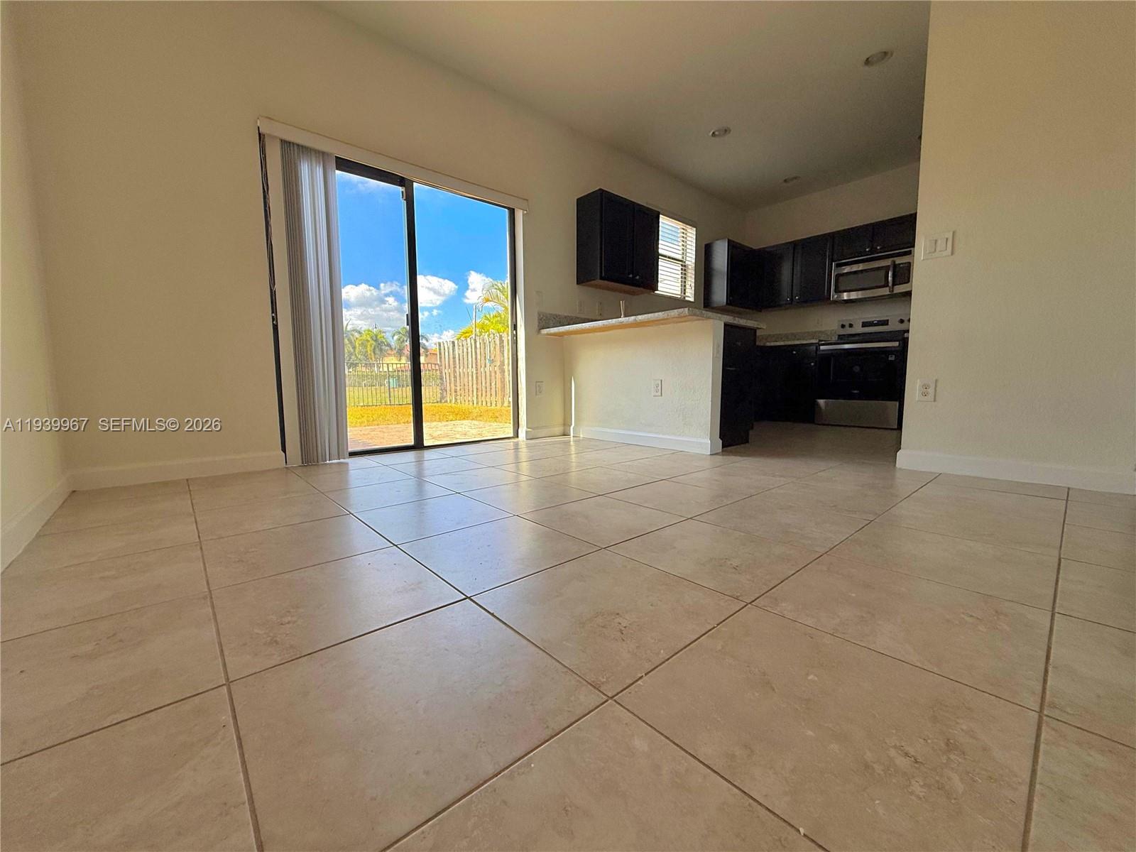 320 Southeast 37th Terrace, Unit 320 Homestead, FL 33033 - Photo 8 of 19 a view of a kitchen with microwave and cabinets