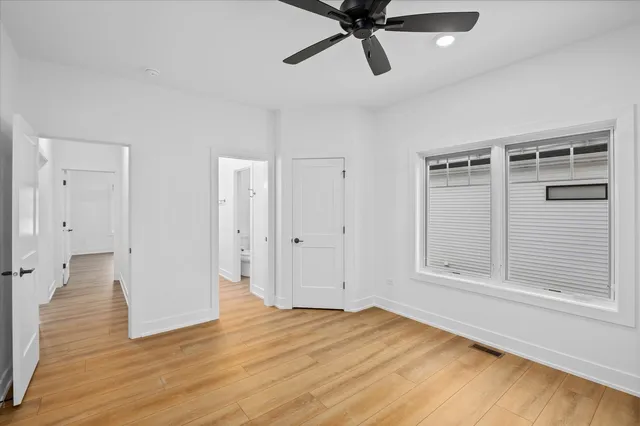 a view of empty room with wooden floor and window