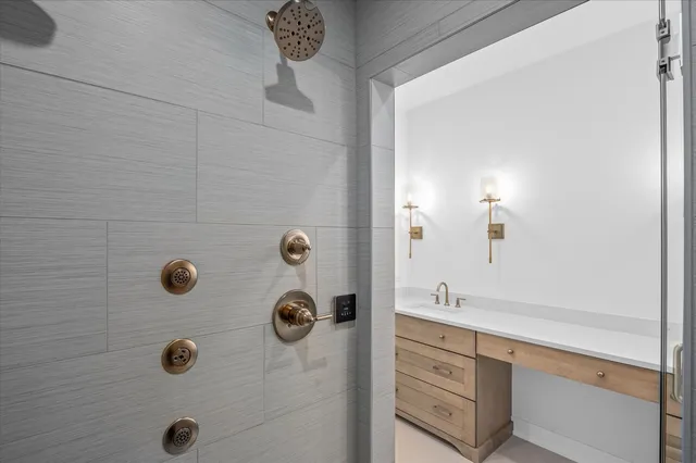 a bathroom with a granite countertop sink a mirror and shower