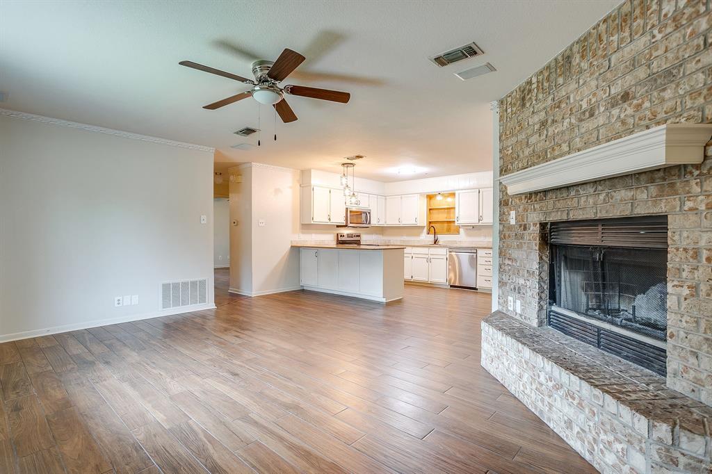 709 North Ave B Springtown, TX 76082 - Photo 8 of 32 a view of a livingroom with a fireplace a ceiling fan a fireplace and windows