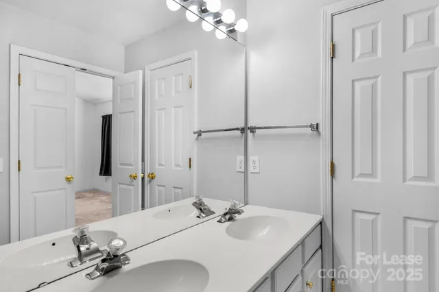 a bathroom with a sink vanity granite and a mirror