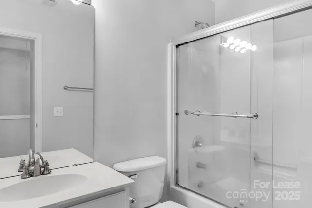 a bathroom with a shower a toilet and a sink