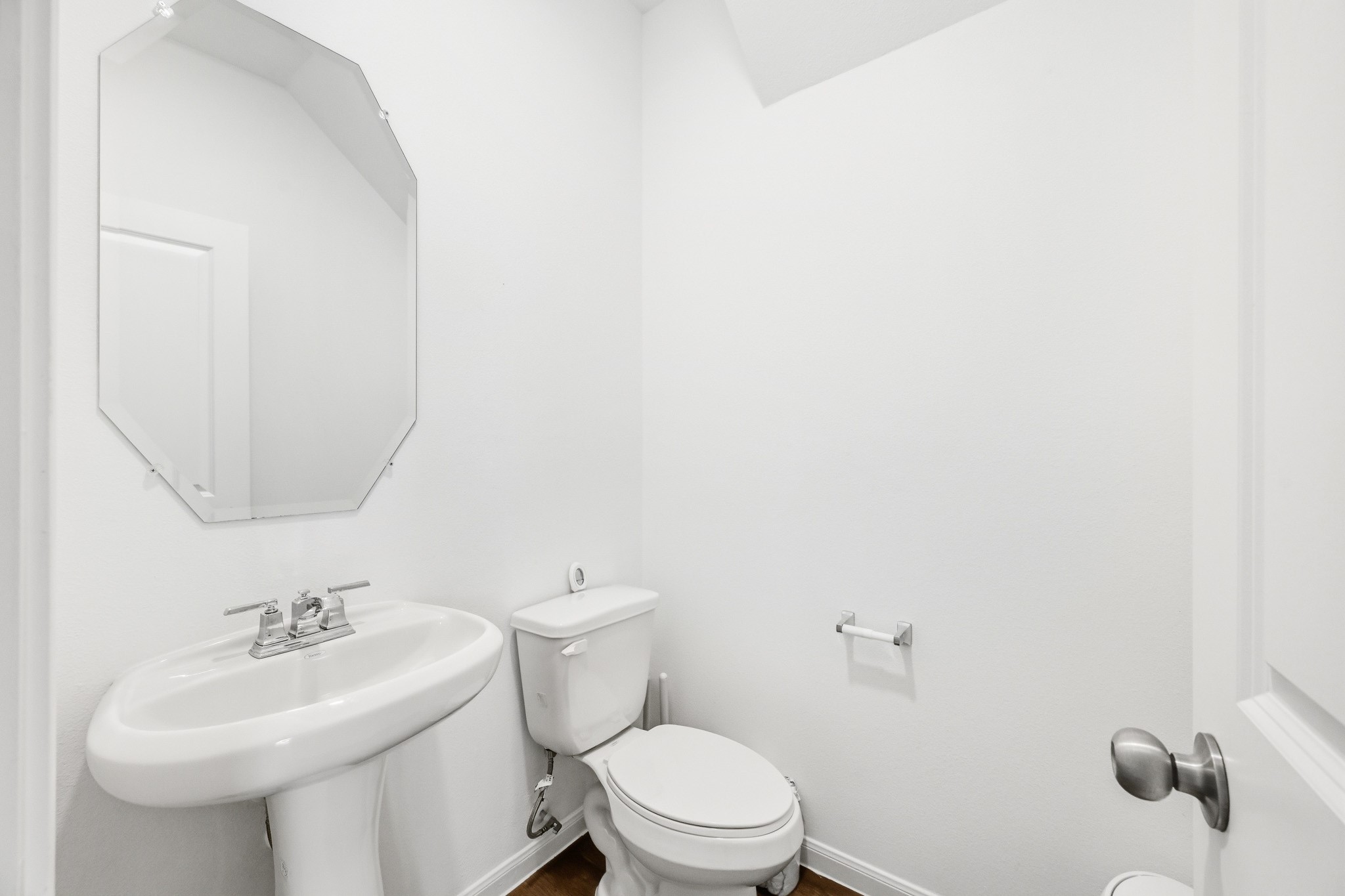 23427 Weir Box Road Hockley, TX 77447 - Photo 21 of 32 A clean, crisp half-bath conveniently located on the main floor. Features bright white walls, an elegant pedestal sink, an decorative octagonal mirror, and low-maintenance flooring.