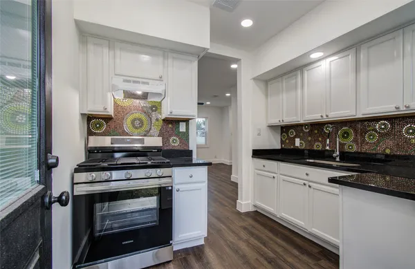 a kitchen with stainless steel appliances a stove a sink and a microwave