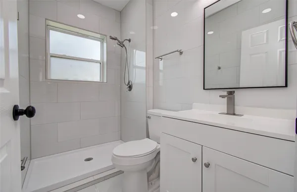 a bathroom with a sink a toilet and shower