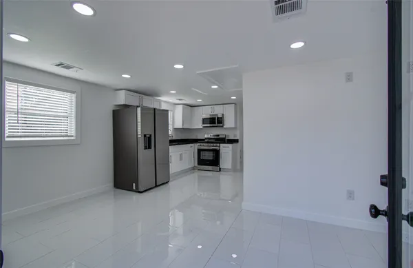 a kitchen with stainless steel appliances kitchen island granite countertop a refrigerator and a stove
