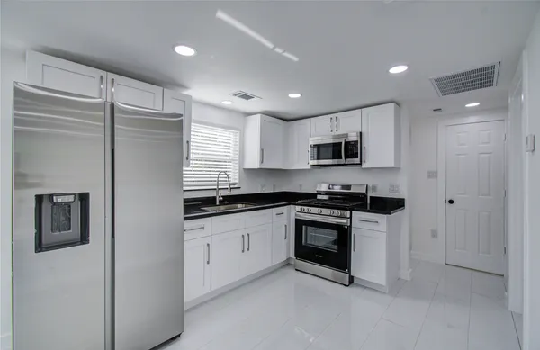 a kitchen with stainless steel appliances granite countertop a stove and a refrigerator