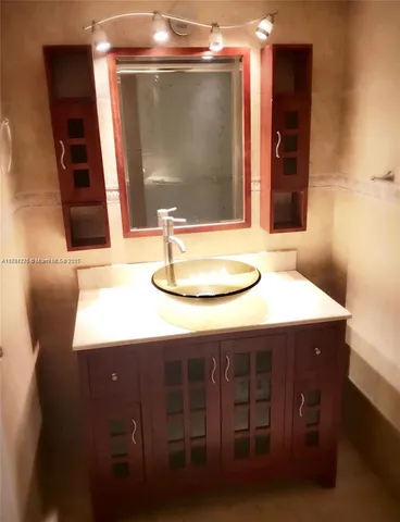 a bathroom with a sink a mirror and a shower
