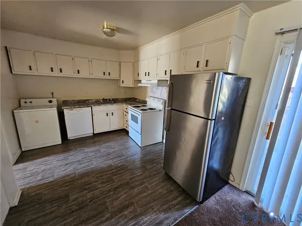 a kitchen with stainless steel appliances a refrigerator sink and wooden floor