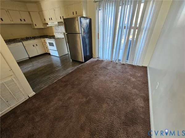 a view of a kitchen with refrigerator and window