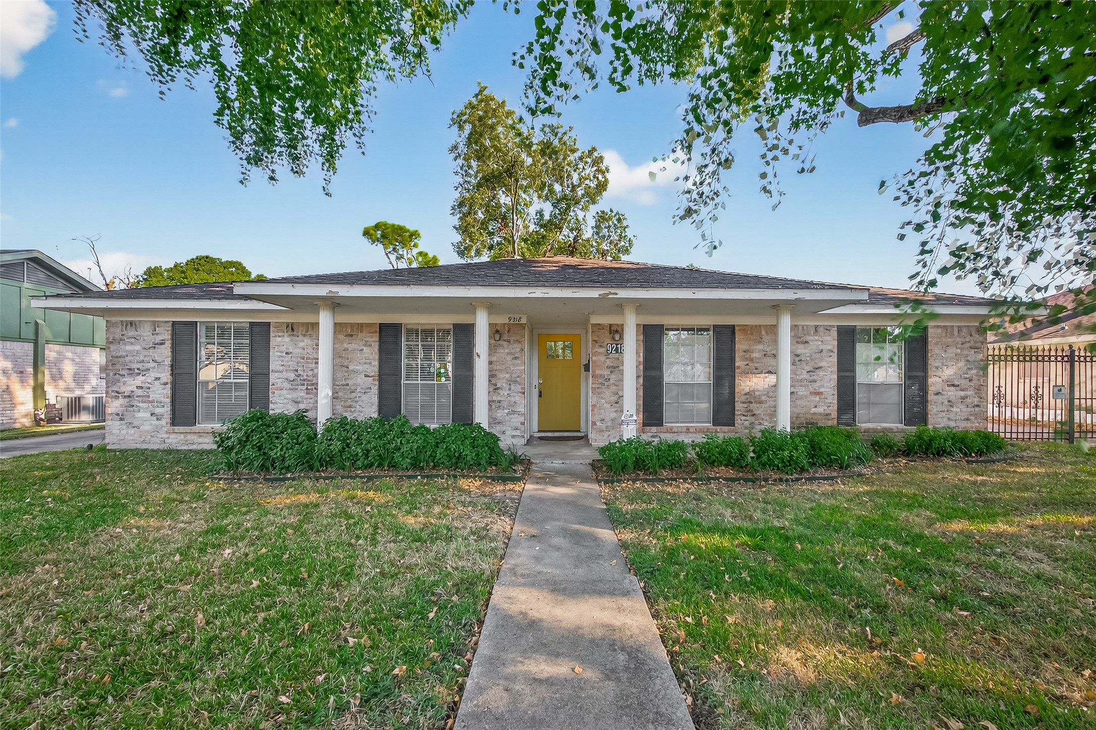 9218 Rowan Lane Houston, TX 77036 - Photo 1 of 32 a view of a brick house with a yard and potted plants