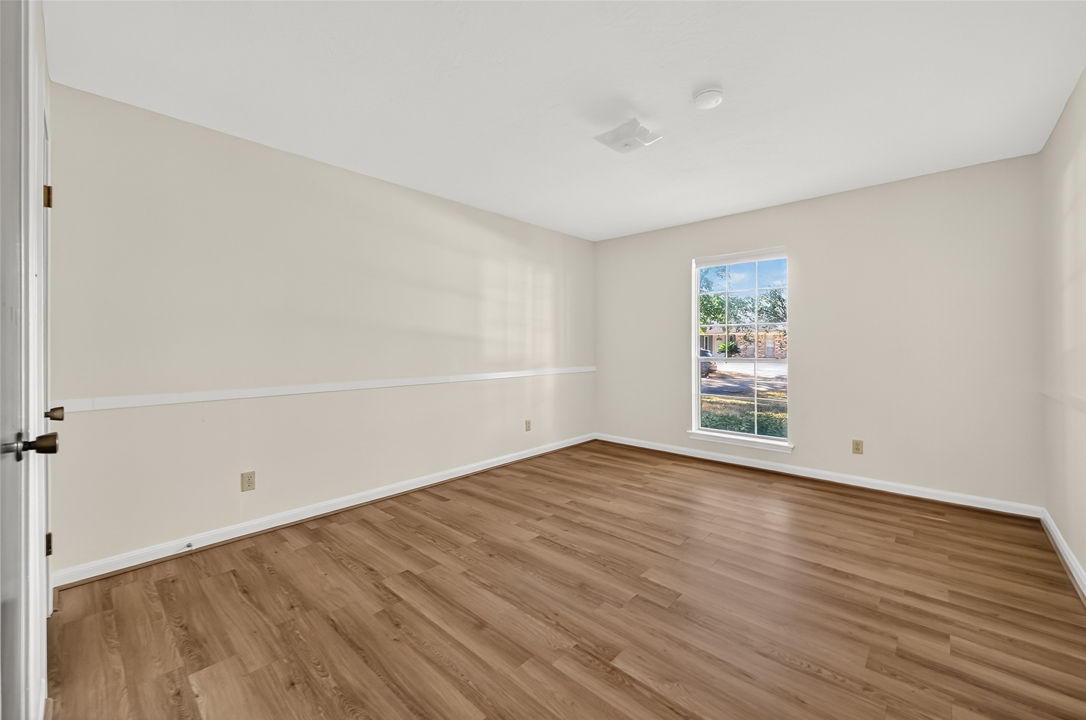 9218 Rowan Lane Houston, TX 77036 - Photo 14 of 32 an empty room with wooden floor and windows