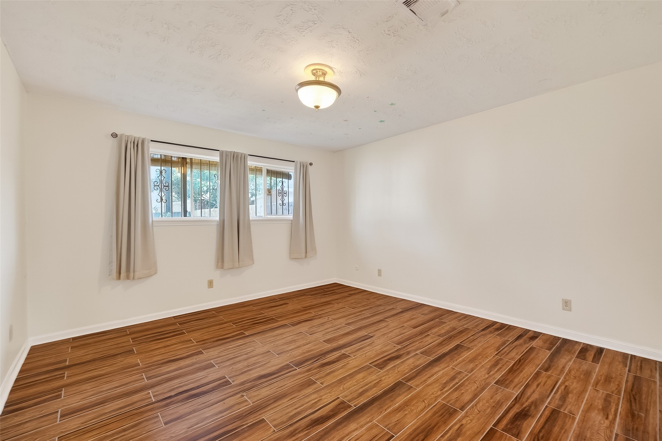 9218 Rowan Lane Houston, TX 77036 - Photo 25 of 32 a view of empty room with wooden floor and fan