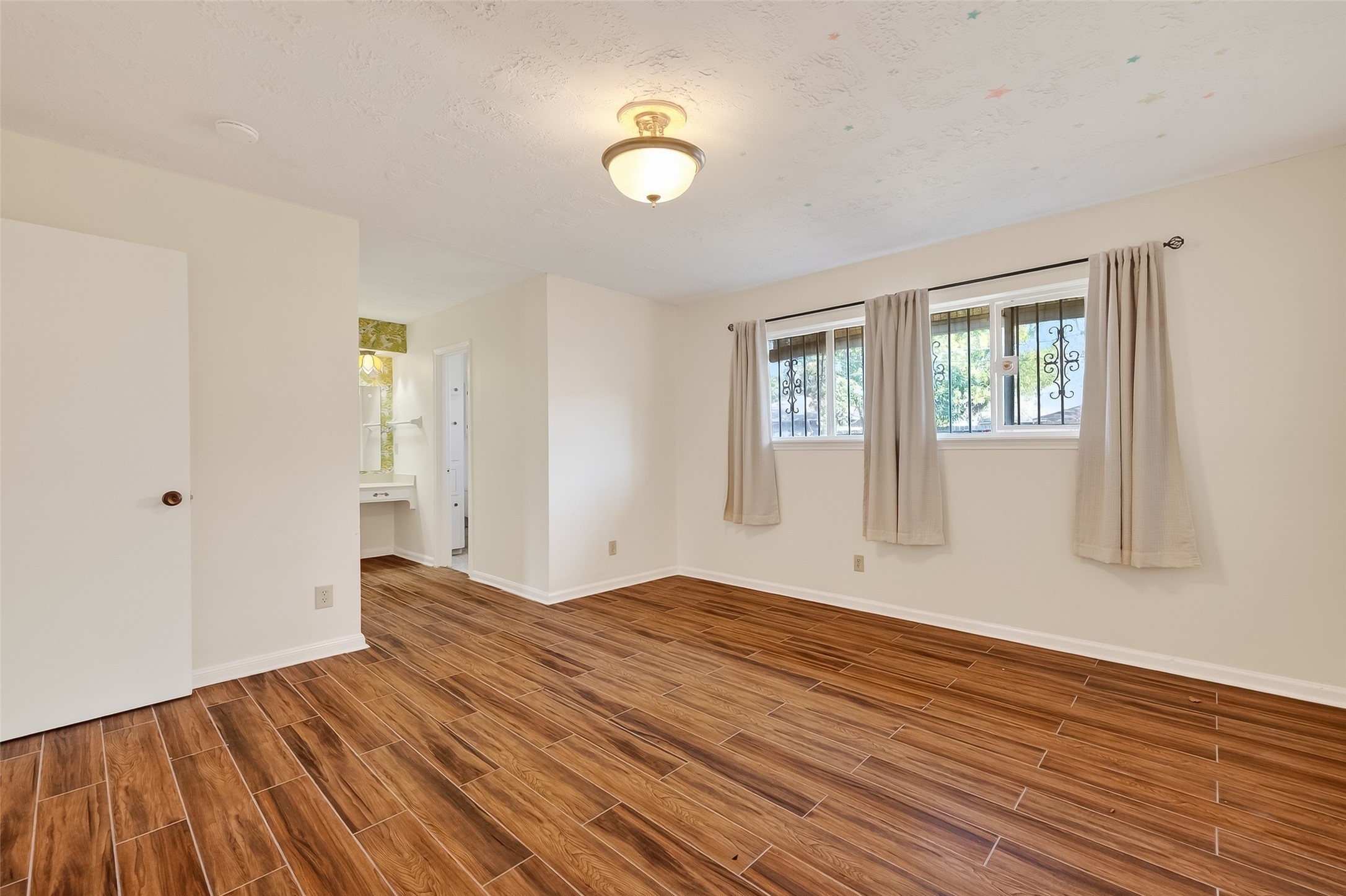 9218 Rowan Lane Houston, TX 77036 - Photo 26 of 32 a view of an empty room with wooden floor and a window