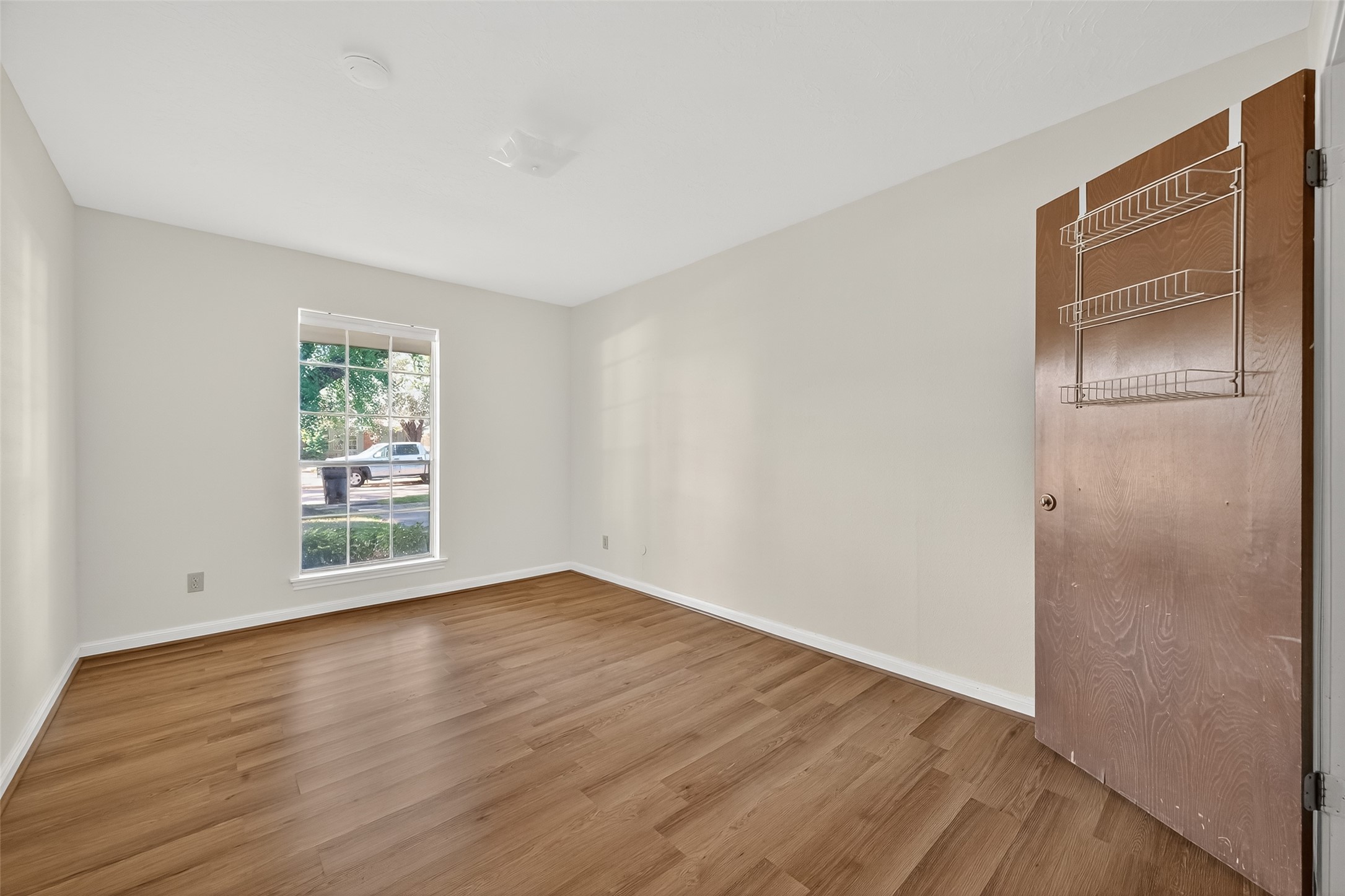 9218 Rowan Lane Houston, TX 77036 - Photo 10 of 32 a view of an empty room with wooden floor and a window