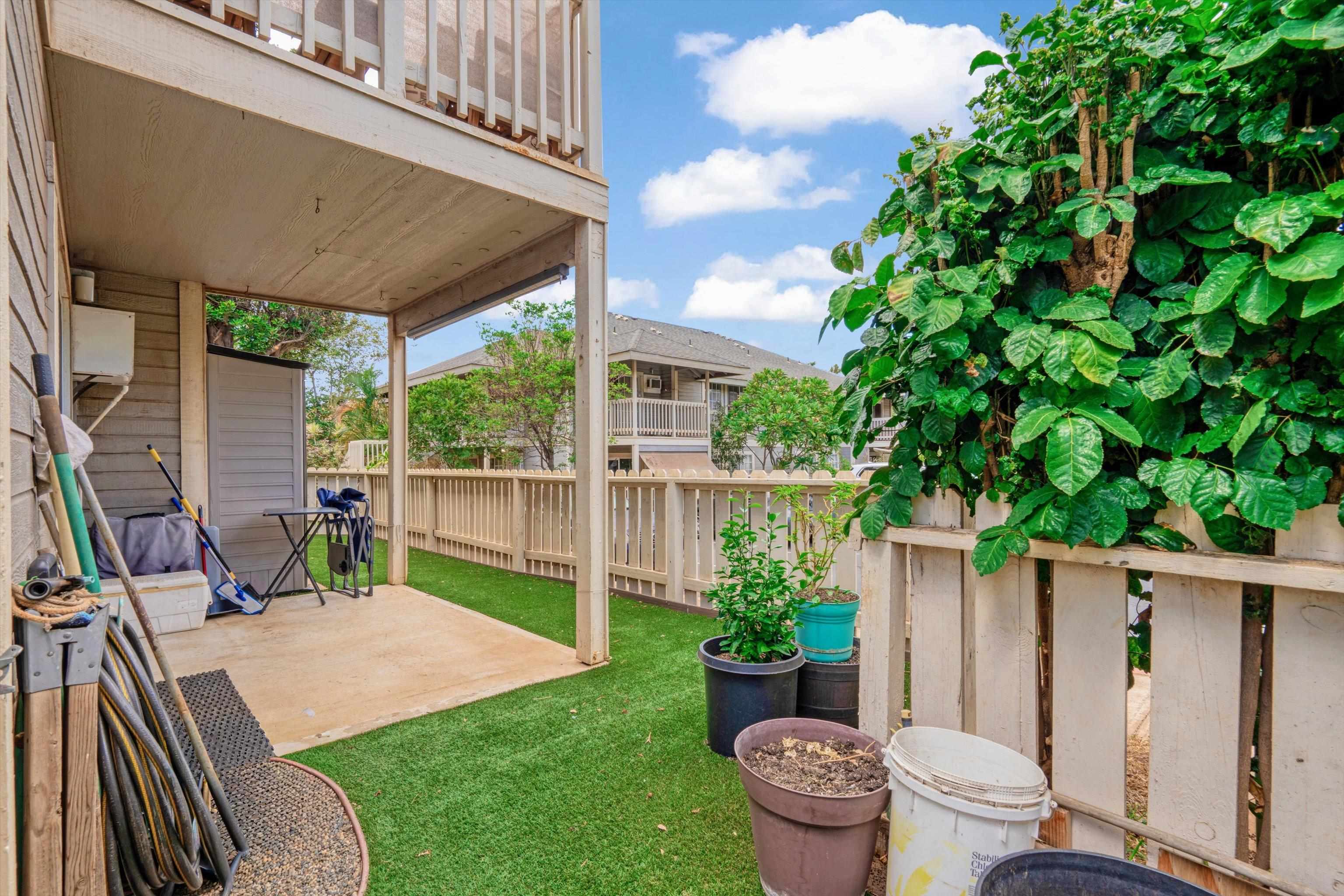 140 Uwapo Road, Unit 19105 Kihei, HI 96753 - Photo 20 of 42 a view of a backyard with table and chairs potted plants and wooden fence